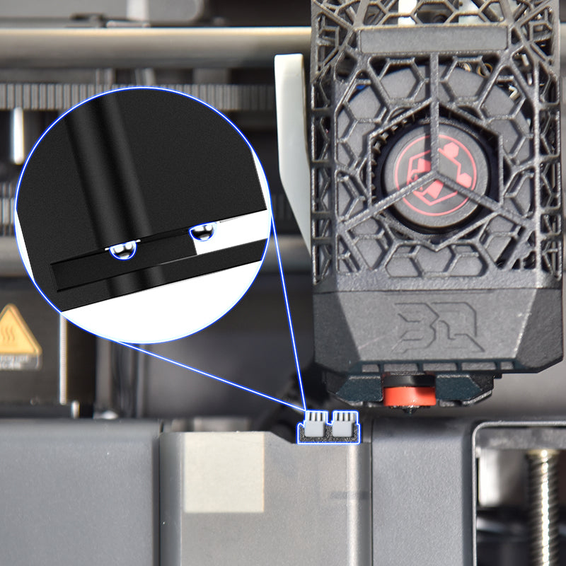 Close-up of a 3D printer with a focus on a component and a magnified detail.