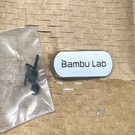 Bambu Lab branded door handle on a textured surface with clear plastic packaging.