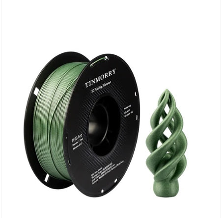 Spool of green 3D printing filament with a printed spiral design on a white background