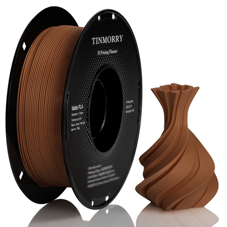 A spool of TINMORRY matte PLA 3D printing filament in a warm brown color, shown next to a 3D-printed vase model that demonstrates the filament's color and texture, on a clean white background with a subtle reflection.