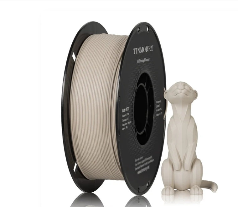 A spool of Tinnormy 3D printing filament in a warm off-white/cream color, shown next to a small 3D-printed figurine of a seated cat on a plain white background.